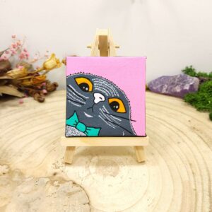 Klein schilderijtje met kat op roze achtergrond